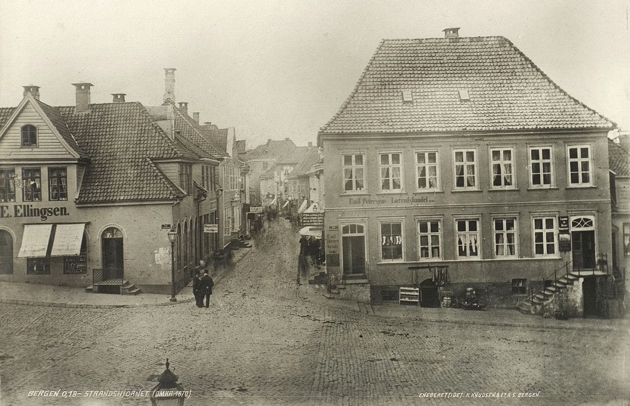 Photograph of a street in Bergen in 1870 with wooden old houses. One of the houses is the apothecary where Ole Bull grew up.