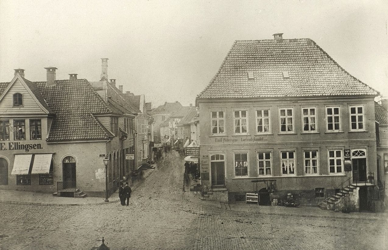 Fotografi av Svaneapoteket i Bergen i 1870. Sorthvitt bilde av gamle trehus.  
