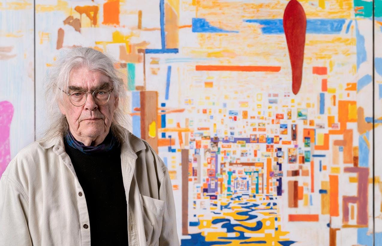Portrettfoto av Arvid Pettersen som viser kunstneren stående foran et av sine malerier.