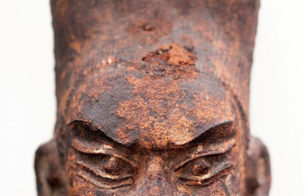 En hodeskulptur, som viser et sint ansikt, laget av jern.