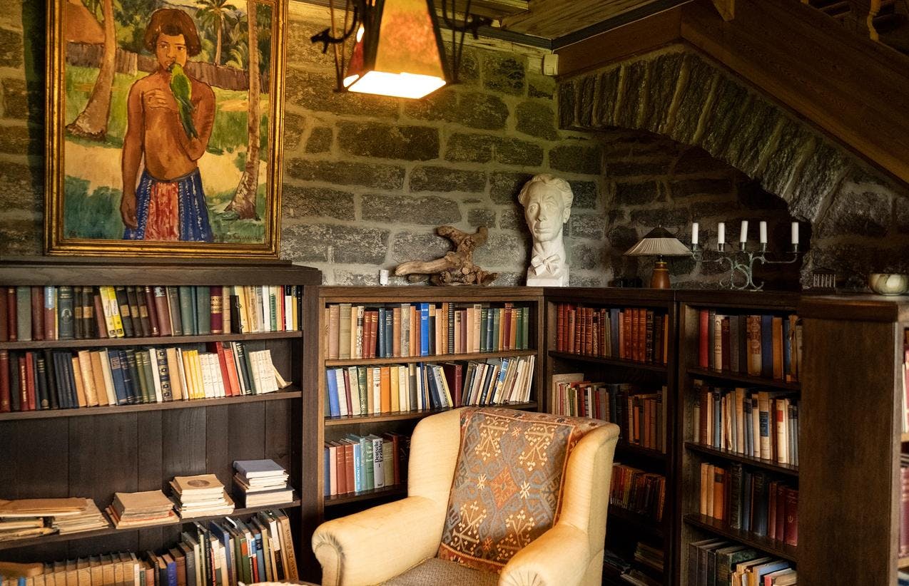 Fra biblioteket på Siljustøl, hvor en lenestol er plassert i en krok mellom bokhyller fulle av bøker. Vi ser også en byste av Harald Sæverud.