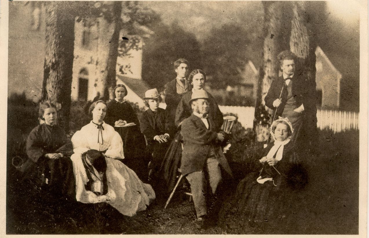 Fotografi av Edvard Grieg og hans familie, utendørs på Landås, ca. 1862.