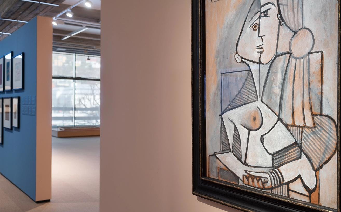 Et maleri av Picasso henger mot en lys rosa utstillingsvegg