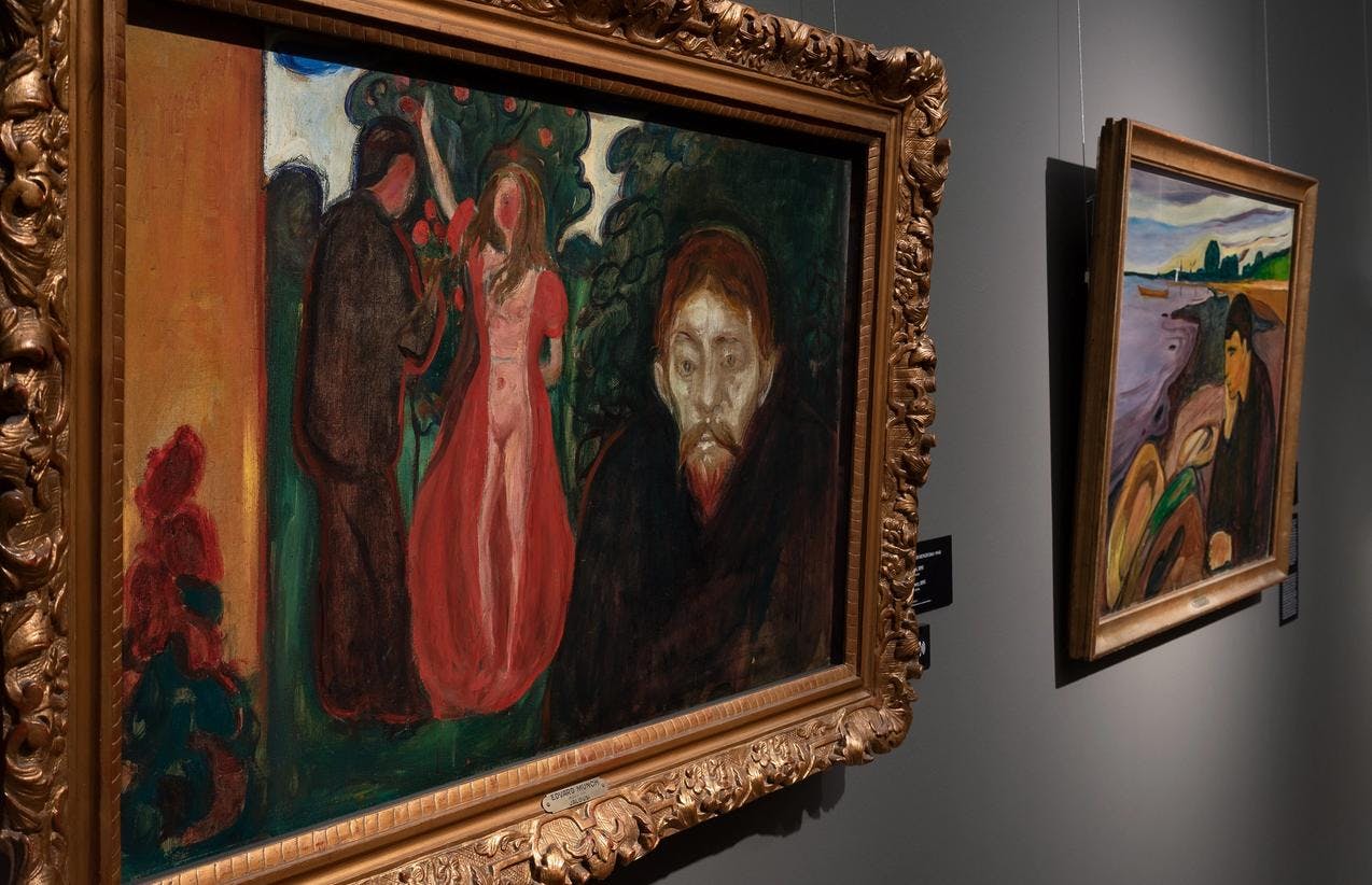 Two paintings by Edvard Munch on a grey exhibition wall