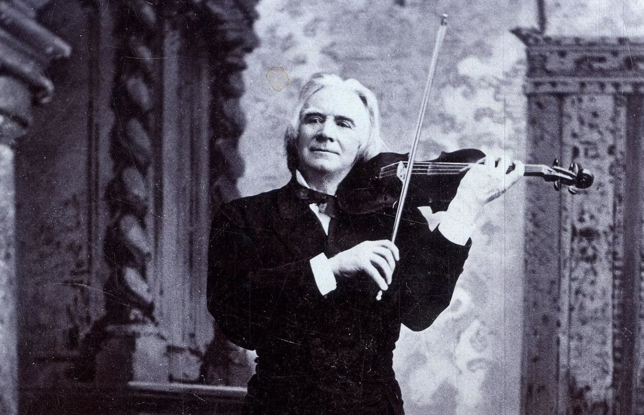 Fotografi av Ole Bull i helfigur, han poserer mens han spiller fiolin.